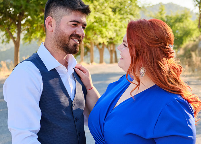 Smiling couple embracing outdoors, highlighting relationship dynamics.