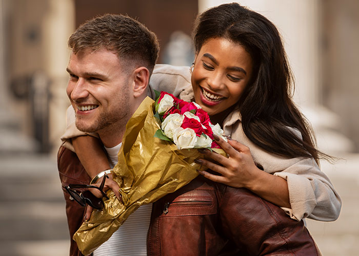Happy couple with red and white roses, illustrating changed perceptions in relationships.