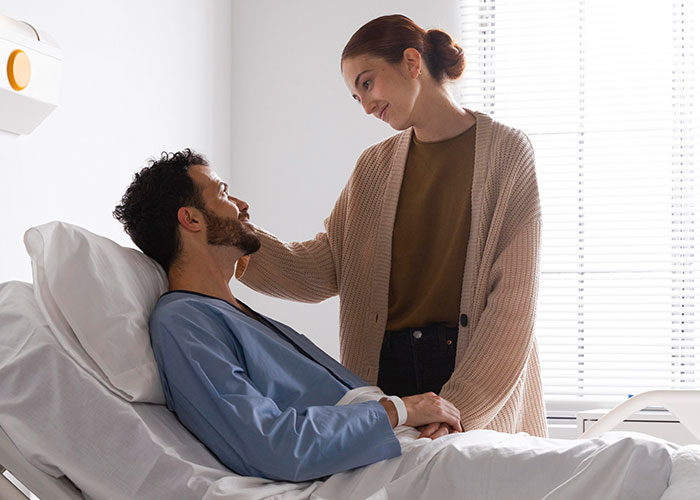 A couple shares a tender moment in a hospital room, highlighting relationship changes after phone discoveries.