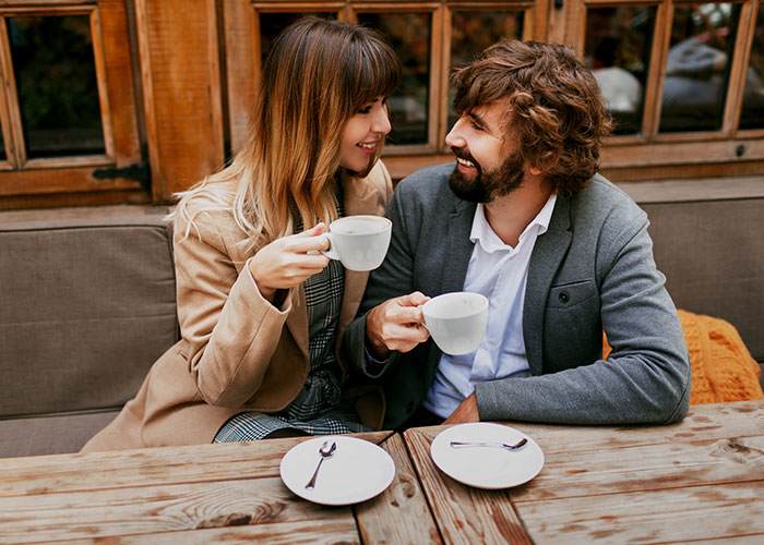Couple enjoying coffee together at an outdoor café, smiling and engaged in conversation, reflecting on what they found.