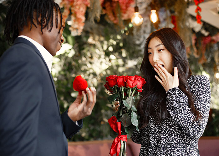 A surprised woman receiving roses and a proposal, highlighting change in relationships.