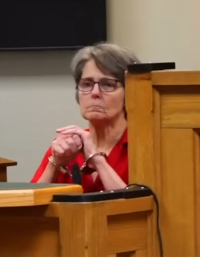 Elderly woman in court in a red shirt, facing sentencing related to hot car incident involving an infant. Elderly woman in court in a red shirt, facing sentencing related to hot car incident involving an infant.