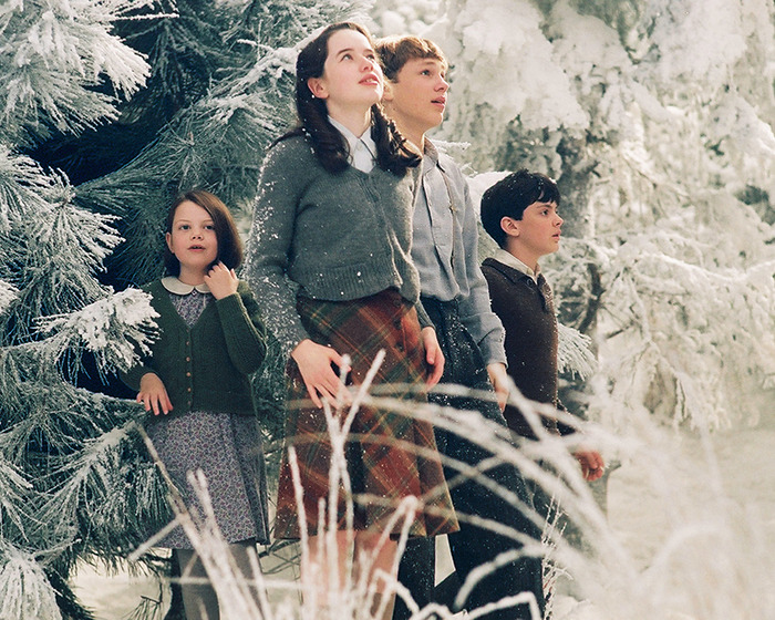 Four children in winter attire stand in a snowy forest scene from the 'Narnia' reboot, sparking gender swap rumors.