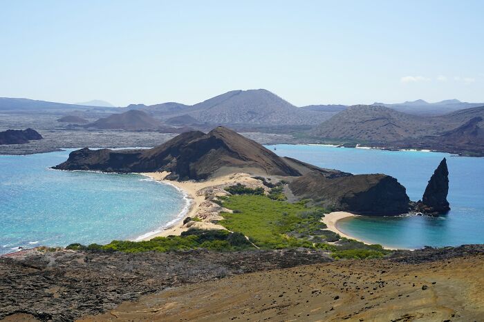 Scenic island with rugged landscape and turquoise waters, impacted by the influence of the wealthy.
