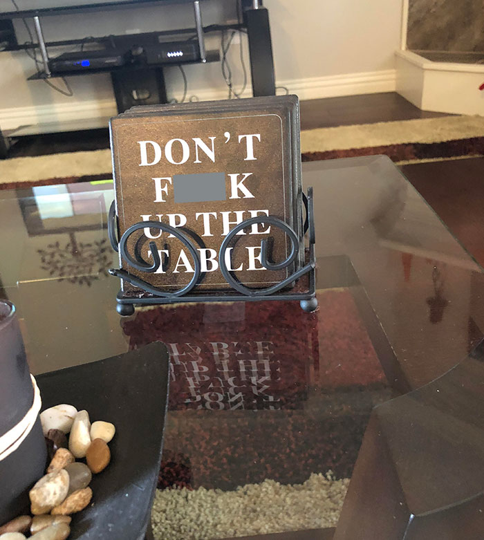 Coaster set with humorous message from elderly people on a living room table.