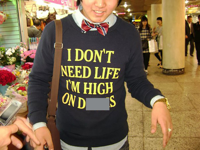 Person in a shopping area wearing a sweater with humorous text about life choices.