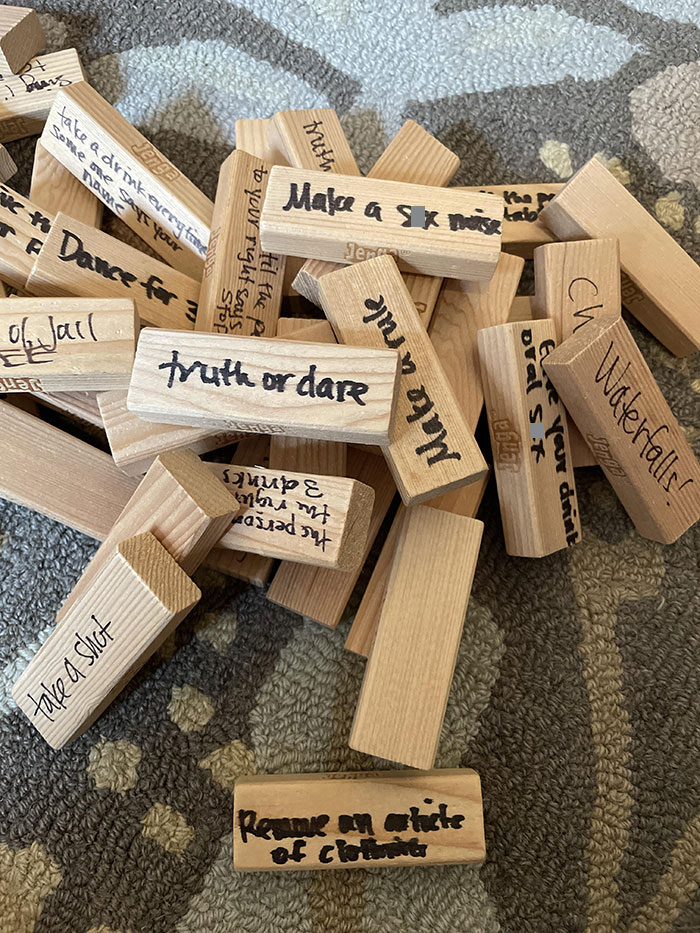 Jenga blocks with tasks written on them, like truth or dare, depicting a chaotic day.