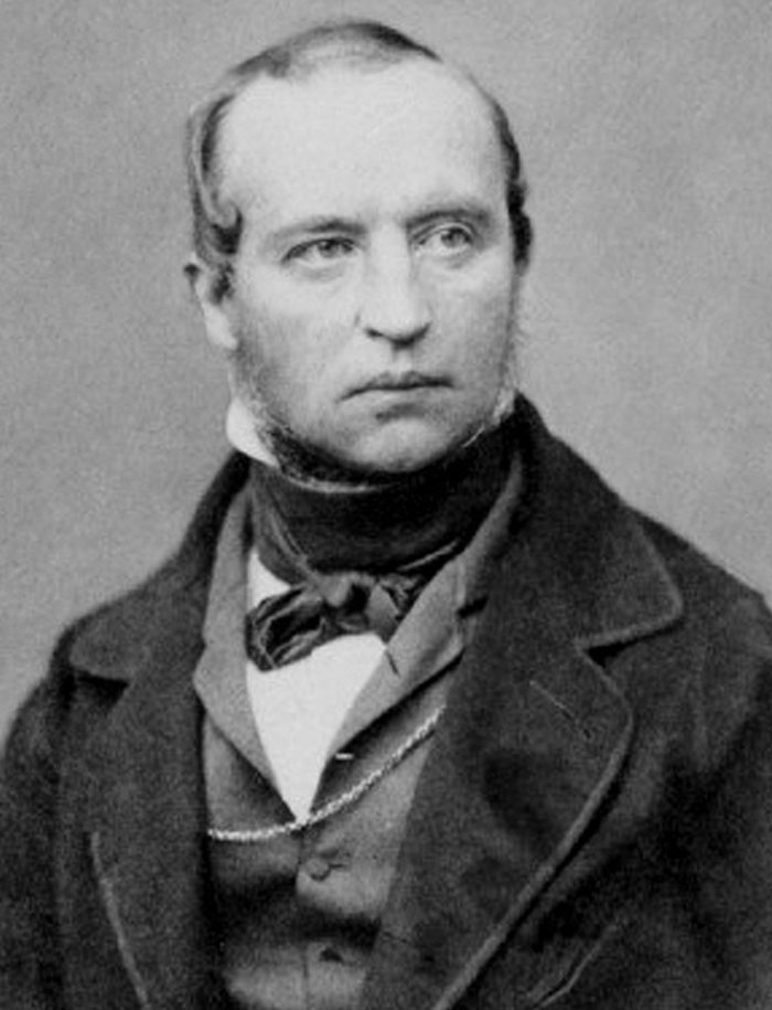 Black and white photo of a man with sideburns in 19th-century attire, suggesting historical event prediction.