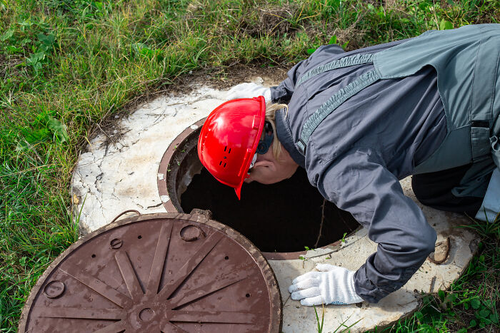 Person in a red hard hat inspecting a well, a useful homeowner first home tip.