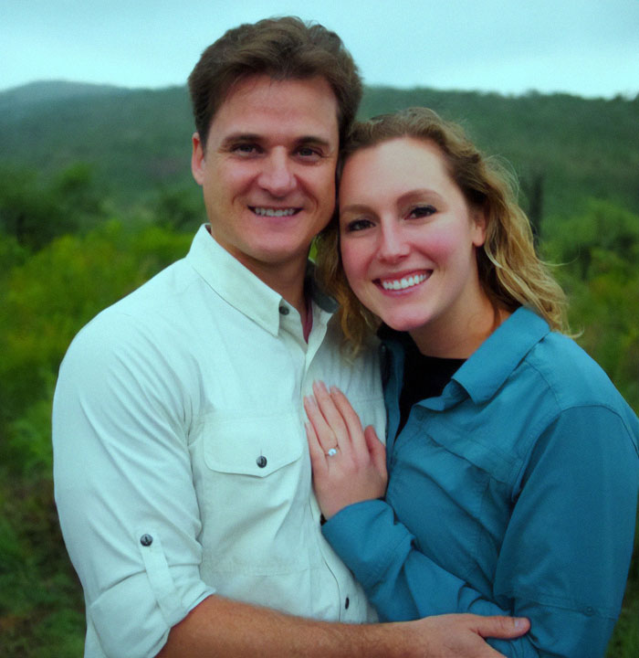 Happy couple standing outdoors against a lush, green landscape. Happy couple standing outdoors against a lush, green landscape.
