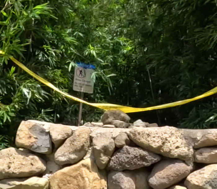 A rocky path with caution tape, highlighting a cliff edge incident involving a doctor. A rocky path with caution tape, highlighting a cliff edge incident involving a doctor.