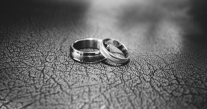 Two silver rings on a textured surface, highlighting unpopular opinions on traditional marriage.