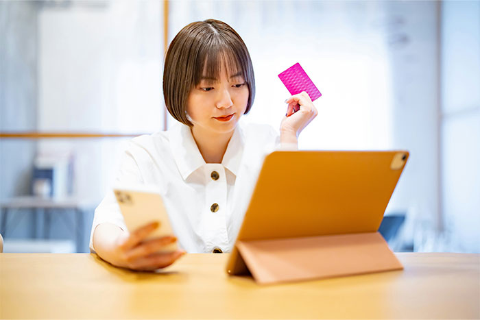 Person checking tablet and holding a card, possibly discovering a cheating partner.