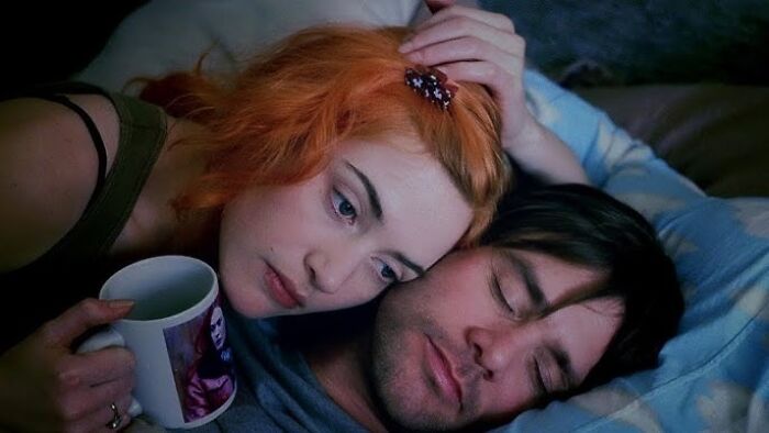 A woman with orange hair comforts a man, evoking tears in a heartfelt movie scene.