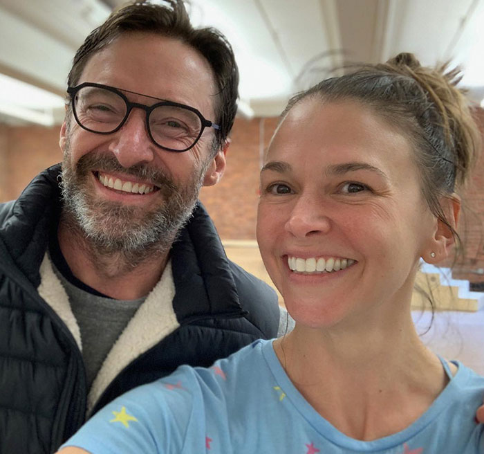 A man in glasses and a woman smiling indoors, focusing on new romance.