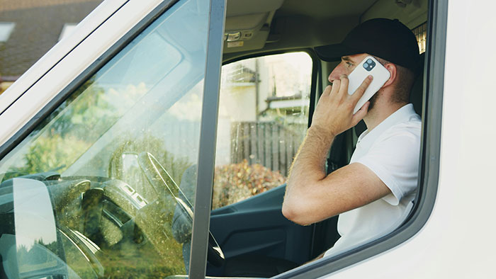 Man in a van talking on phone, symbolizing long daily calls. Man in a van talking on phone, symbolizing long daily calls.