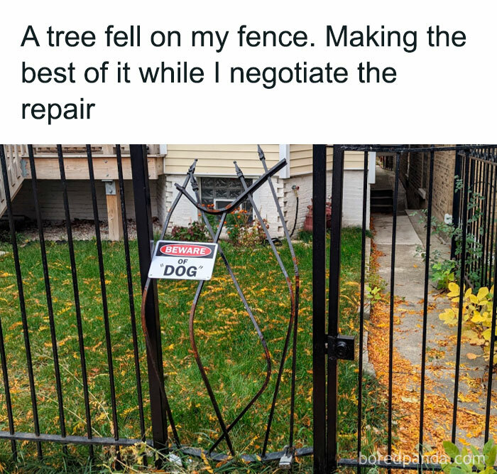 Damaged fence with a bent "Beware of Dog" sign, showcasing humor and sarcasm.
