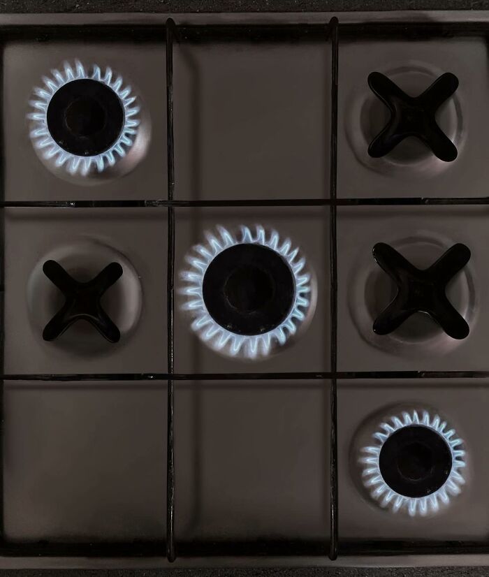 Tic-tac-toe board with stove burners as innovative artwork by artist.