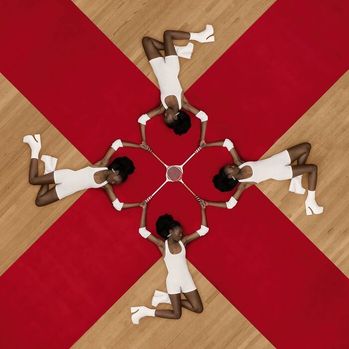 Aerial conceptual photography with four women in white, holding tennis racquets, forming a geometric pattern on a red cross background.