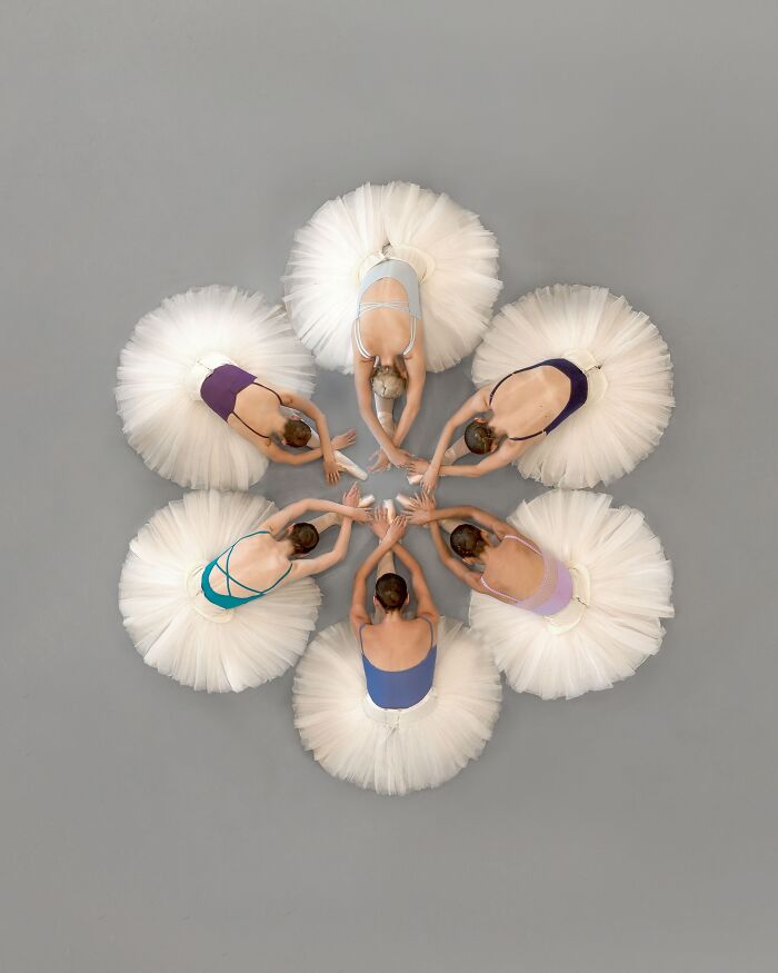 Aerial view of ballerinas in white tutus forming a star shape, showcasing conceptual photography.