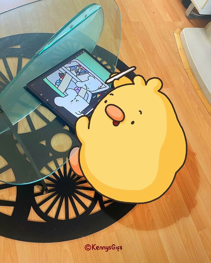 Cute cartoon "Birb" interacting with tablet art in real world setting by Kenny Mays.