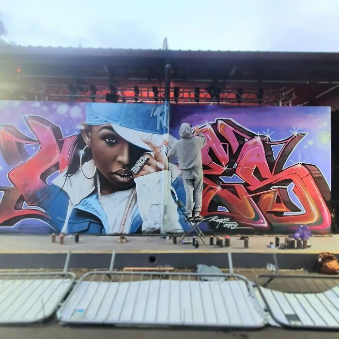 Artist paints captivating mural on Glasgow wall, featuring vibrant graffiti and portrait.