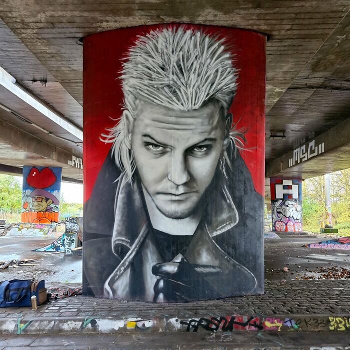 Mural of a man with spiky hair and leather jacket on a textured wall in Glasgow.