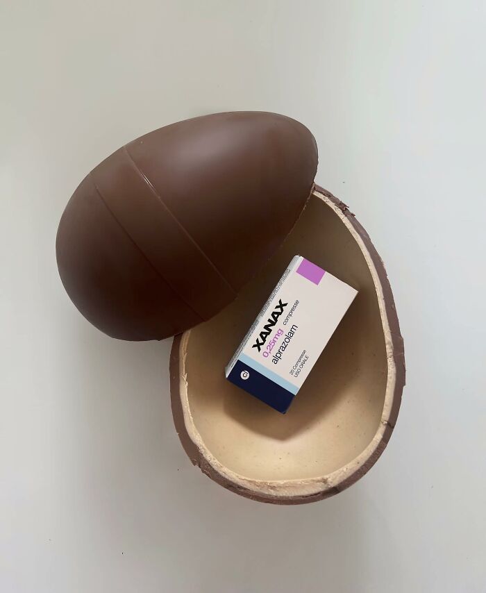 Chocolate egg opened revealing a box of Xanax, showcasing thought-provoking artwork using common items.