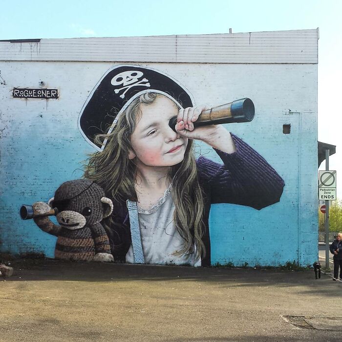 Mural in Glasgow of a girl with a pirate hat and telescope, painted on a building wall.