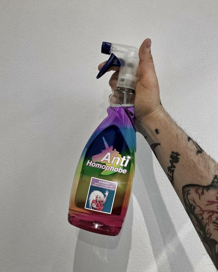 Hand holding spray bottle transformed into thought-provoking artwork labeled "Anti Homophobe" with a rainbow design.