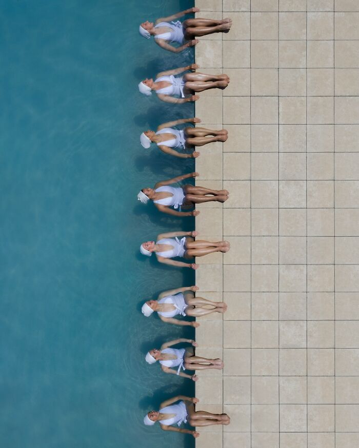 Aerial conceptual photography of synchronized swimmers by the pool.