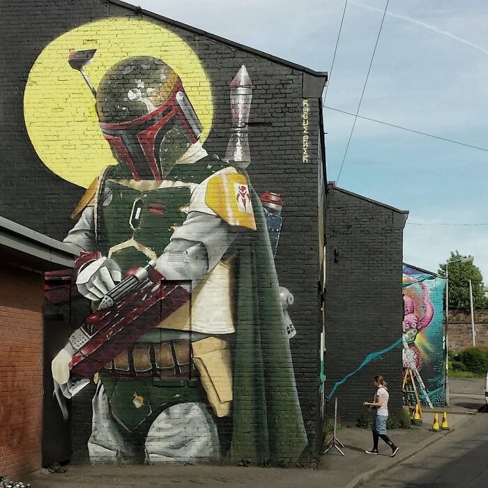Glasgow mural depicting a sci-fi warrior character on a brick wall, painted by a local artist.