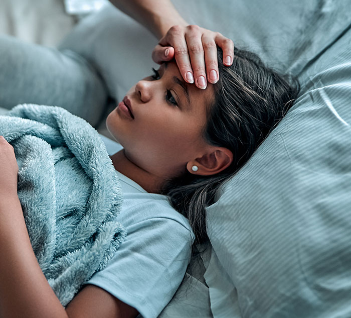 Child in bed with hand on forehead, illustrating unhinged medical diagnosis concerns.