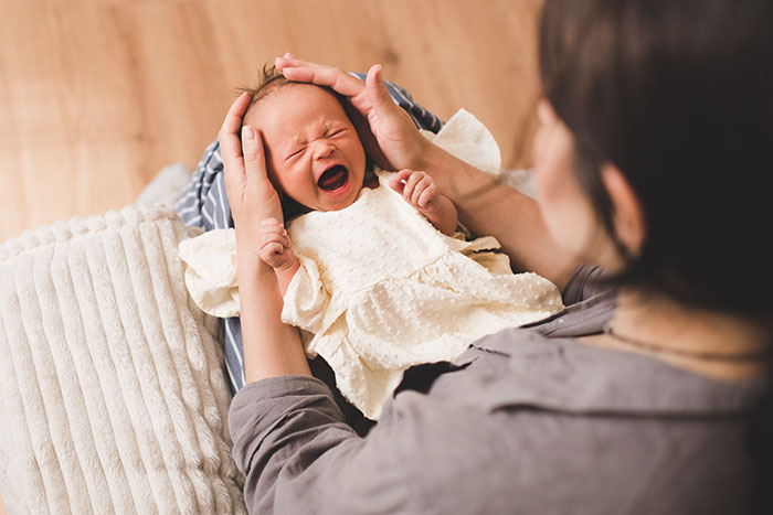 A parent soothing a crying baby, illustrating an incorrect medical diagnosis.