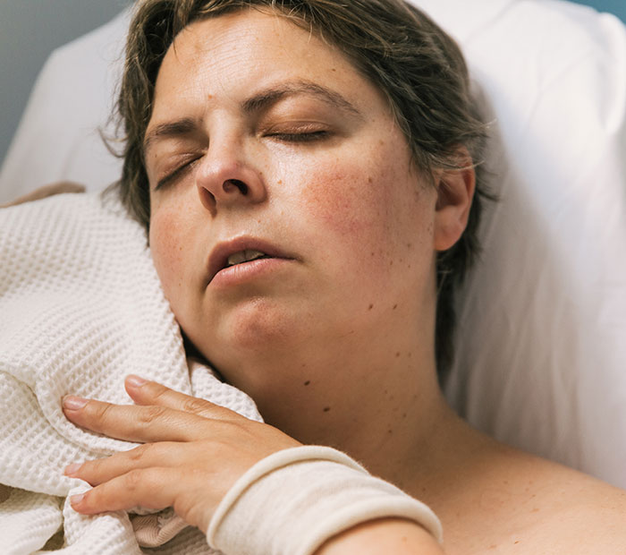 Person resting in a hospital bed, illustrating stress from an incorrect medical diagnosis.