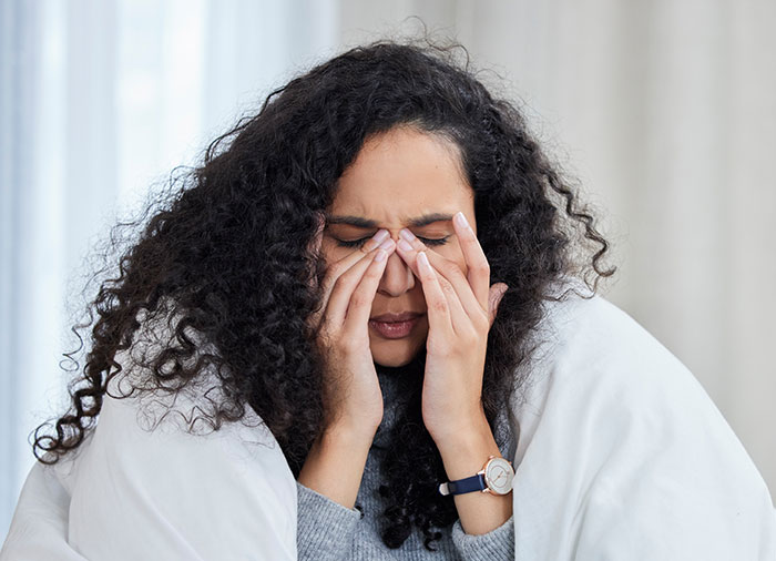 Woman in distress, holding her face; representing incorrect medical diagnosis.