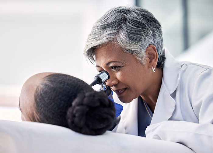Doctor examining a patient's eyes for potential medical diagnosis.