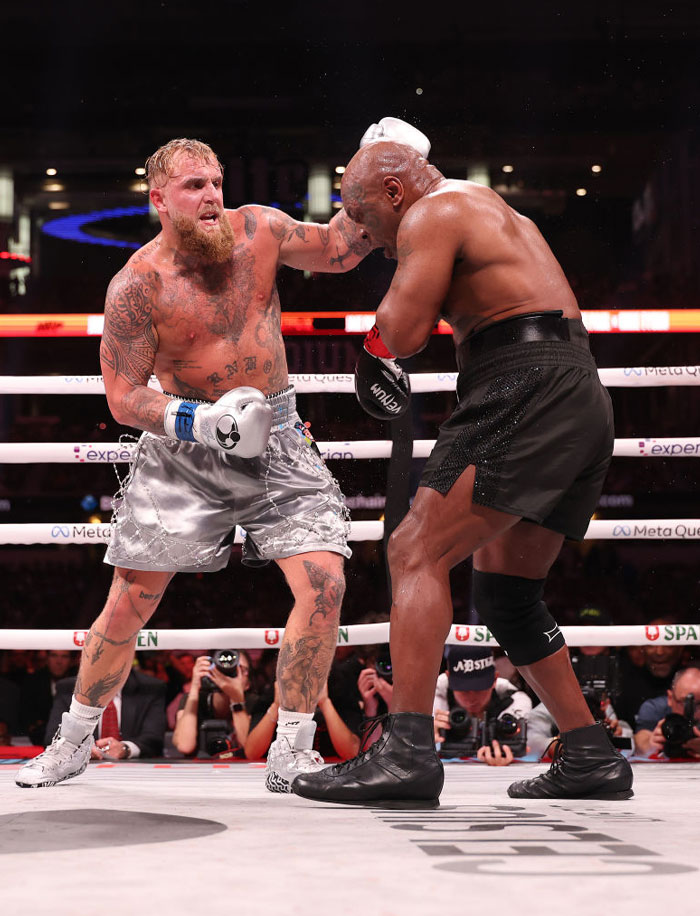 Jake Paul delivering a punch in the ring showcasing YouTube fame turned athletic pursuit.