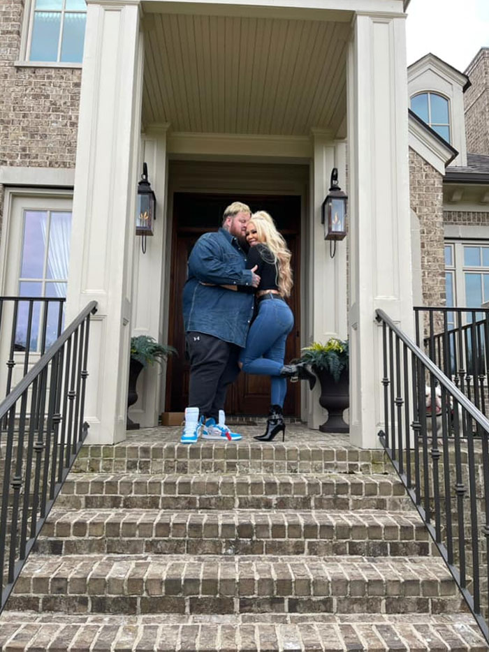 Couple embraces on front steps, showcasing Jelly Roll&rsquo;s journey from rock bottom to rock star.