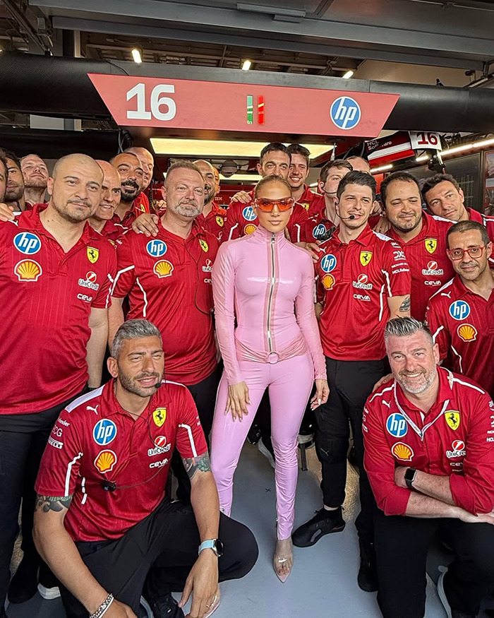 Person in pink catsuit with Ferrari team at Saudi F1 race.