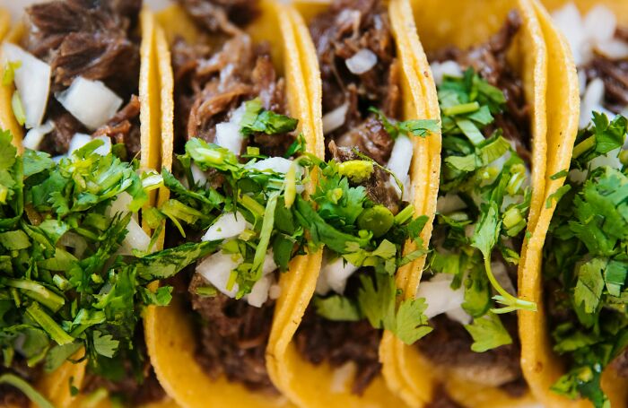Close-up of delicious tacos filled with meat, onions, and cilantro, showcasing a tempting dining loophole.