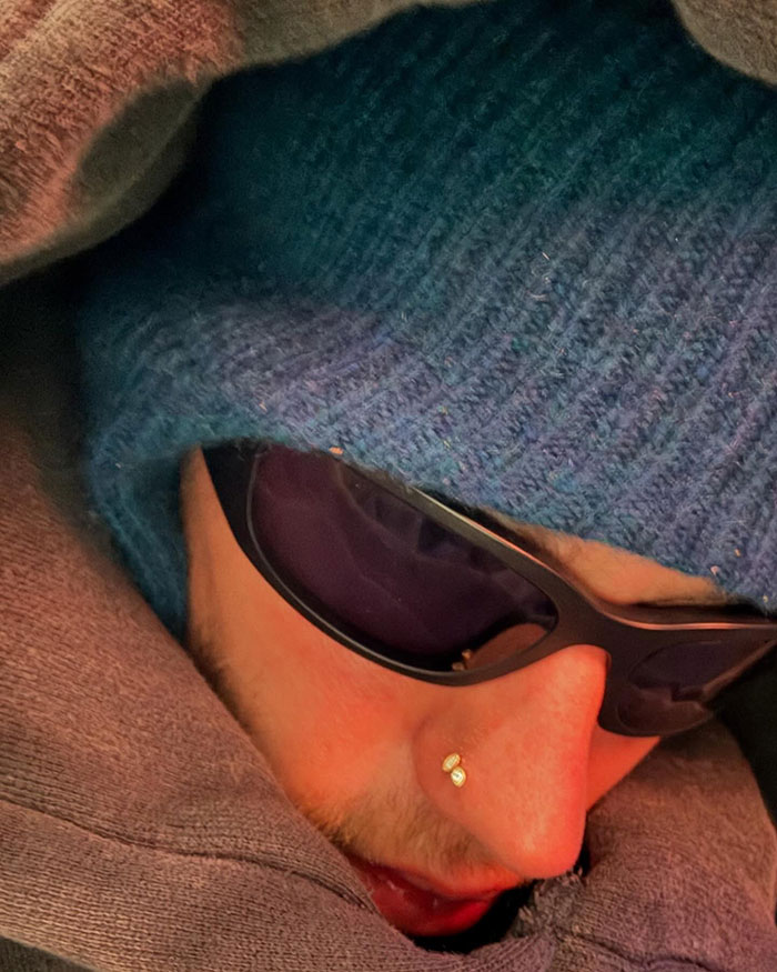 Person wearing sunglasses and a blue knit hat, face partially covered.