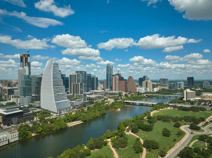 Skyline view of a US travel destination with modern buildings and a river under a blue sky.