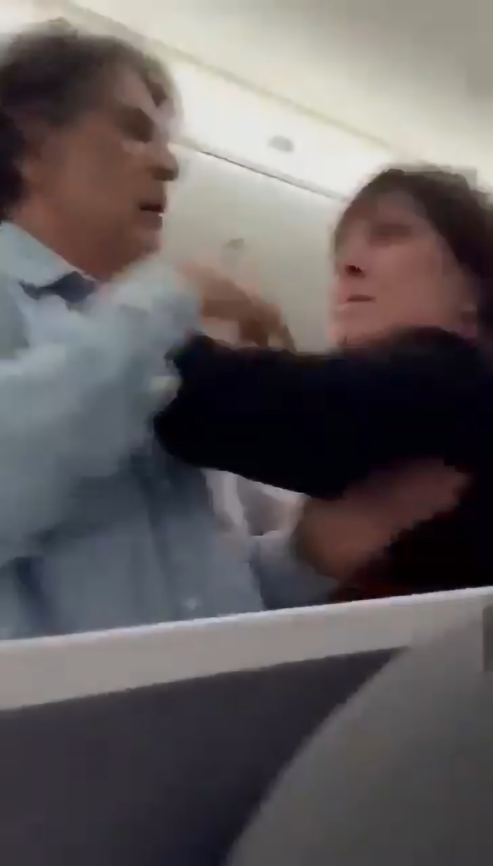 Passenger tries to storm cockpit during flight delay, getting tackled by crew amid onboard confrontation.