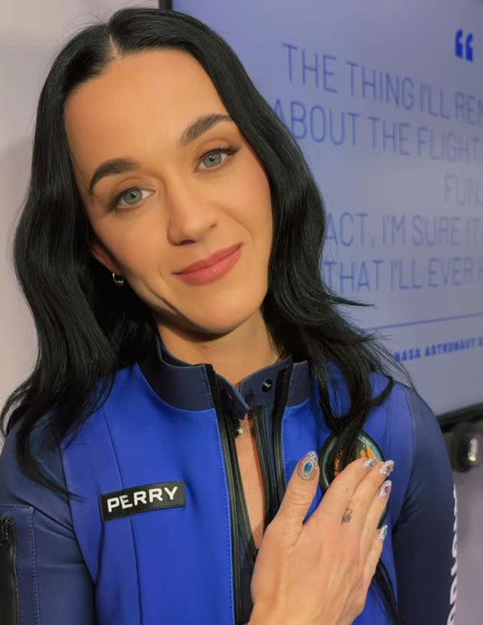 Singer in a blue outfit, hand on chest, showing support amid recent mockery in media.