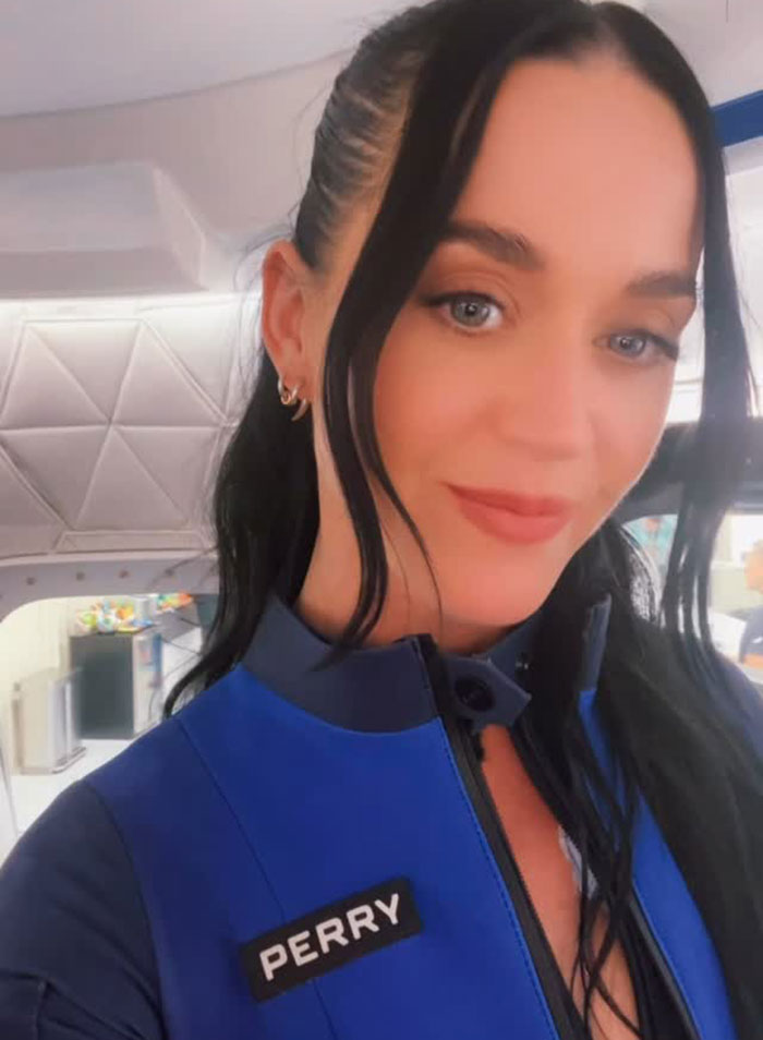 Katy Perry in a Blue Origin flight suit, posing inside a spacecraft before her space flight experience.