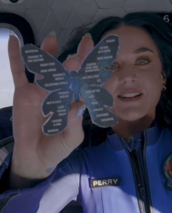 Katy Perry smiles, holding a butterfly cutout, showing massive support amidst recent controversies.