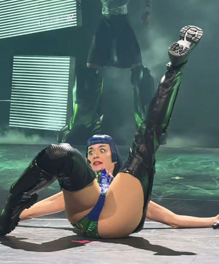 Performer in concert costume on stage, mid-dance with theatrical expression, showcasing energetic tour debut dance moves.