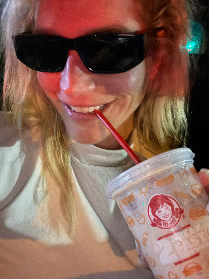 Person in sunglasses holding a Wendy's cup, related to massive support for Katy Perry incident.