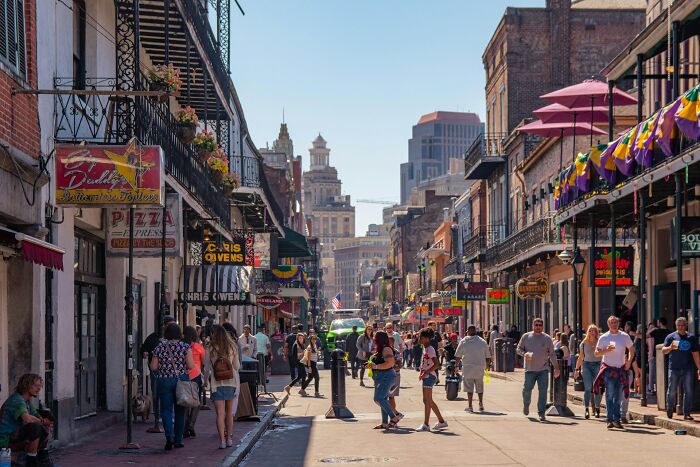 Bustling street scene with people walking past shops and restaurants, highlighting places that aren't as cool to live in.